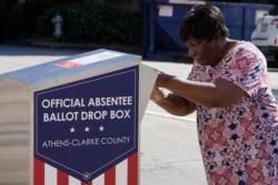 A voter drops off her ballot during early voting in Athens, Ga., Oct. 19, 2020. (AP)