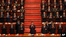 Chinese President Xi Jinping, front row center, applauds with party members during the Communist song at the closing ceremony for the 19th Party Congress at the Great Hall of the People in Beijing, Tuesday, Oct. 24, 2017. (AP Photo/Andy Wong))