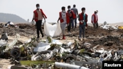 Ethiopian Red Cross workers carry a body bag with the remains of Ethiopian Airlines Flight ET 302 plane crash victims at the scene of a plane crash, near the town of Bishoftu, southeast of Addis Ababa, Ethiopia March 12, 2019. REUTERS/Baz Ratner.