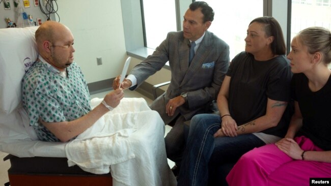 Aaron James looks at his face in a mirror for the first time after a whole-eye transplant in New York in this undated photo. ( NYU Langone Health/Handout via REUTERS)