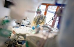 FILE - A nurse treats a patient with COVID-19 in the intensive care unit of Bethel Hospital in Berlin, Germany, Nov. 11, 2020.