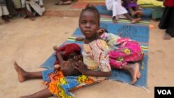 FILE - A girl rescued from the Sambisa forest cradles another girl in her lap at a displaced persons camp in Malkohi, Nigeria, May 5, 2015. (C. Stein/VOA)