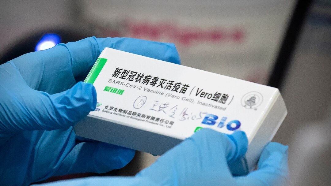 FILE - A medical worker holds a package for a Sinopharm vaccine at a vaccination facility in Beijing, Jan. 15, 2021.
