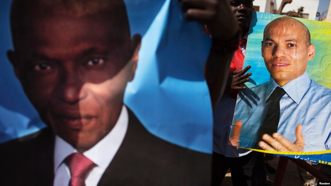 FILE - Supporters of main opposition Senegalese Democratic Party hold posters of former Senegalese president Abdulaye Wade (L) and his son Karim (R) during a protest in Dakar April 23, 2013.