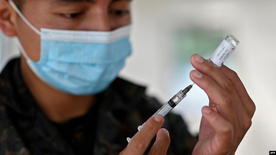 Un soldado prepara una dosis de la vacuna AstraZeneca contra COVID-19, en un centro de vacunación de la Plaza de la Constitución, en la Ciudad de Guatemala, el 25 de agosto de 2021, en medio de un repunte en el número de casos de coronavirus.