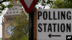 FILE - A sign points to where residents can cast their votes in London, May 3, 2024. U.K. voters are set to cast ballots in a national election on July 4, 2024.