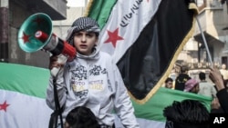 Syrian youth with megaphone leads rally supporting the Free Syrian Army in the Aleppo's Bustan al-Qasr district, January 4. (AP)