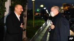 Presiden Azerbaijan Ilham Aliyev (kiri) menyambut hangat kedatangan Presiden Turki Recep Tayyip Erdogan dalam jamuan resmi makan malam di Baku, Azerbaijan, Rabu (9/12). 