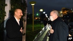 Turkey's President Recep Tayyip Erdogan, right, and Azerbaijan's President Ilham Aliyev greet each other before a private dinner, in Baku, Azerbaijan, Dec. 9, 2020.