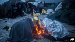 Para migran di Pulau Lesbos, Yunani yang kedinginan membuat perapian di sekitar kamp sementara mereka (foto: dok).