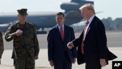 President Donald Trump passes Joint Chiefs Chairman Gen. Joseph Dunford, left, and National Security Adviser Michael Flynn as he arrives via Air Force One at MacDill Air Force Base in Tampa, Fla.