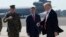 President Donald Trump passes Joint Chiefs Chairman Gen. Joseph Dunford, left, and National Security Adviser Michael Flynn as he arrives via Air Force One at MacDill Air Force Base in Tampa, Fla.