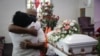 En esta fotografía de archivo del 21 de julio de 2020, Darryl Hutchinson, de frente, recibe el abrazo de un pariente durante el funeral de Lydia Nunez, prima del primero, en la Iglesia Bautista Metropolitana en Los Ángeles. Lydia Nunez falleció de COVID.
