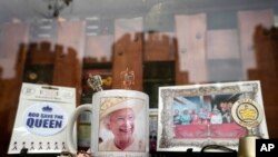 Windsor Castle is reflected in the window of a shop selling Royal souvenirs outside the Castle, in Windsor, England, Oct. 22, 2021. Britain's Queen Elizabeth II spent a night in a hospital for checks this week after canceling an official trip to Northern 