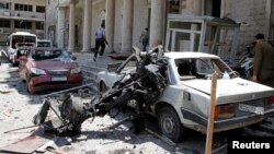 Security personnel walk in front of the former Interior Ministry building after a blast at Marjeh Square in Damascus, Syria, Apr. 30, 2013.