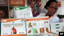 FILE - Health worker Sylvia Marettah Katende displays reproductive health products and information at a family planning exhibition in Kampala, Uganda, Sept. 26, 2017.