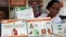 FILE - Health worker Sylvia Marettah Katende displays reproductive health products and information at a family planning exhibition in Kampala, Uganda, Sept. 26, 2017.