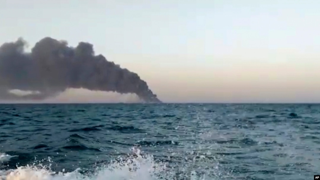 This image made from a video released on Wednesday, June 2, 2021 by Asriran.com, shows smoke rising from Iran's navy support ship Kharg in the Gulf of Oman.