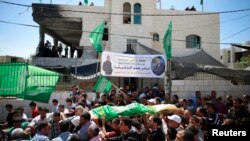 Palestinians carry the body of Amar Abu Aysha, who was shot dead by Israeli troops, during his funeral in the West Bank city of Hebron, Sept. 23, 2014.