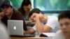 FILE - University of Miami student Gabriel Dias studies the daily lesson plan on his computer during a Spanish class in Coral Gables, Florida, Sept. 9, 2013. 