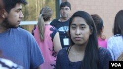 Edith Galvan, an undocumented immigrant and DACA recipient, talks to people at a small protest outside the county jail in Raleigh, North Carolina. It was the first protest organized by the Meredith College student. (A. Barros, VOA)