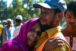 A Rohingya refugee woman who is among those being moved to an island called ‘Bhasan Char’ cries outside a transit area where they are temporally housed in Ukhiya, Bangladesh, Dec.3, 2020.