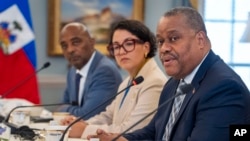 FILE - Haiti's Prime Minister Garry Conille, right, sits next to Foreign Minister Dominique Dupuy during a meeting with Secretary of State Antony Blinken, July 2, 2024, at the State Department in Washington.