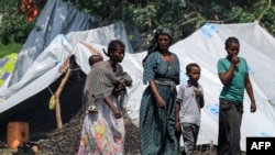 Perempuan dan anak-anak di sebuah kamp pengungsi Ethiopia dari kelompok etnis Qemant di desa Basinga, distrik Basunda, wilayah Gedaref timur Sudan, 10 Agustus 2021. (Foto: ASHRAF SHAZLY / AFP)
