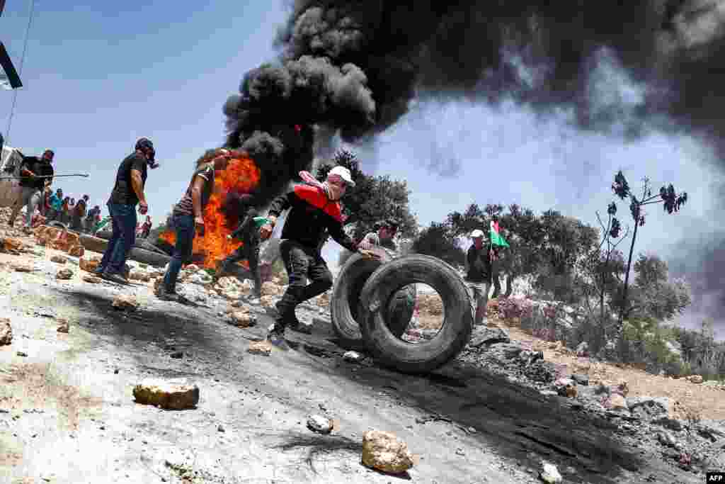 요르단강 서안 나블루스에서 팔레스타인 시위대가 이스라엘 군과의 충돌 중 타이어를 불태우고 있다.