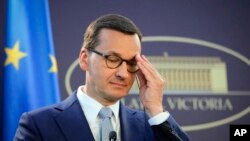 FILE - Polish Prime Minister Mateusz Morawiecki adjusts his glasses during a press statement in Bucharest, Romania, Sept. 18, 2019. Morawiecki said Friday that he expects Marian Banas, head of Poland's audit office, to resign. 