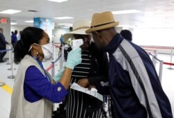 Travelers arriving into Haiti at the International Airport Toussaint Louverture on February 4, 2020, get their temperature checked as part of the measures to prevent the entry of coronavirus in Haiti.