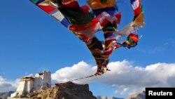 FILE - Prayer flags fly at Namgyal Tsemo Monastery above the town of Leh in Ladakh, India, Sept. 24, 2016. 