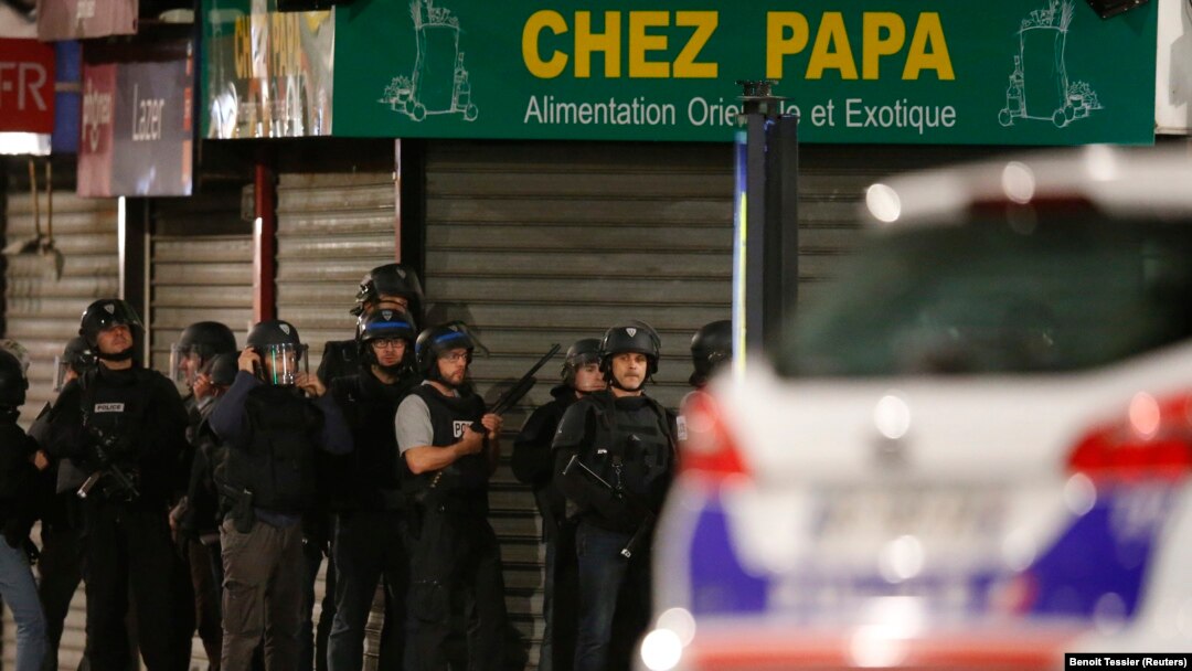 Polisi Perancis mengamankan wilayah dalam adu tembak di Saint-Denis, dekat Paris (18/11), dalam operasi berburu buronan. (Reuters/Benoit Tessier)