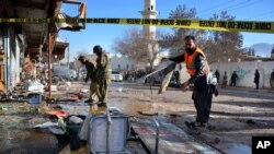 Pakistani security officials examine at the site of suicide bombing in Quetta, Pakistan, Wednesday, Jan. 13, 2016. The suicide attack on a polio vaccination center in southwestern Pakistan killed more than a dozen people and wounded many.