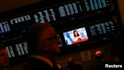 FILE - Attendants of a ceremony at Buenos Aires' Stock Exchange watch as Argentina's President Cristina Fernandez de Kirchner speaks, in Buenos Aires, Aug. 20, 2014. 