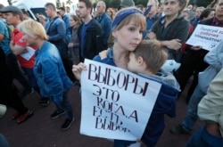 A woman holds a poster that reads: "Elections are when you can choose," as people gathered for a protest in St. Petersburg, Russia, Sept. 5, 2019.