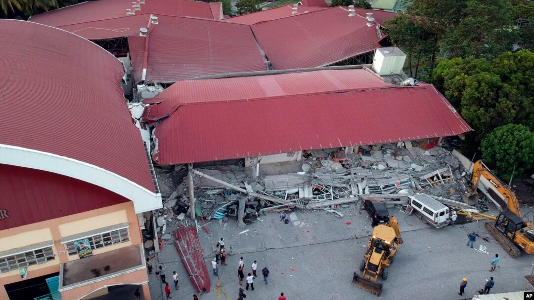 Para petugas terus melanjutkan pencarian korban di antara reruntuhan gedung yang ambruk akibat digoncang gempa di kota Porac, provinsi Pampanga, utara Filipina, 22 April 2019. 