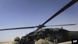 FILE - In this Sept. 6, 2011, a U.S Army flight medic Spc. Zacharye Menzie, right, from Albuquerque N.M, along with medical nurses of U.S. Marines, carry a wounded Afghan Army soldier to a medevac helicopter from the U.S., Army's Task Force Lift "Dust Off