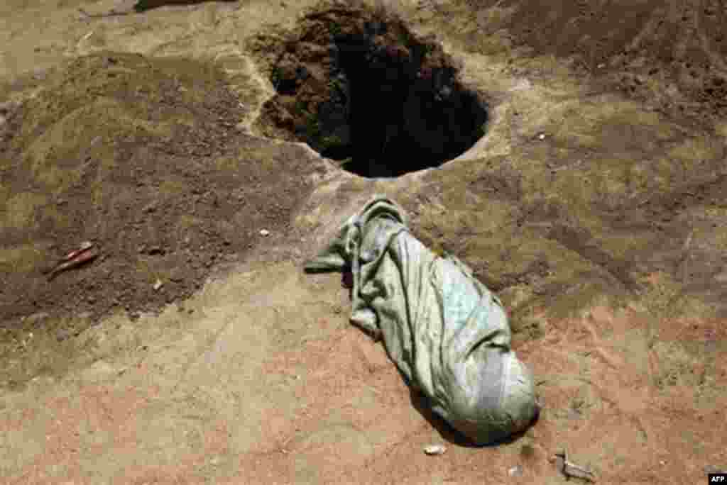 CORRECTS DATE-The shrouded body of 12-month-old Liin Muhumed Surow lays before burial at UNHCR's Ifo Extention camp outside Dadaab, Eastern Kenya, 100 kms (60 miles) from the Somali border,Saturday Aug. 6, 2011. Liin died of malnutrition 25 days after 