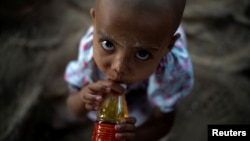 A migrant girl looks on at a village near the Thai-Myanmar border in Mae Sot, Thailand, Jan. 7, 2022.