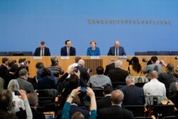 German Chancellor Angela Merkel, 2nd right, attends a federal press conference about the coronavirus outbreak in Germany, in Berlin, March 11, 2020.