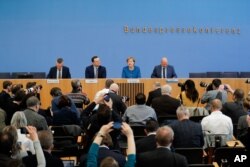 German Chancellor Angela Merkel, 2nd right, attends a federal press conference about the coronavirus outbreak in Germany, in Berlin, March 11, 2020.
