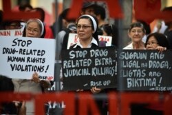 FILE - Catholic nuns hold placards as they protest against what organizers say are drug-related extrajudicial killings, during International Human Rights Day in Manila, Philippines, Dec. 10, 2016.