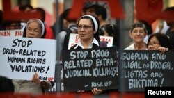 FILE - Catholic nuns hold placards as they protest against what organizers say are drug-related extrajudicial killings, during International Human Rights Day in Manila, Philippines, Dec. 10, 2016. 