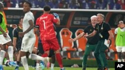 South Africa's coach Hugo Broos rushes to hug his captain and goalkeeper Ronwen Williams as they celebrate after winning in the quarterfinals of the Africa Cup of Nations against Cape Verde, at the Charles Konan Banny stadium in Yamoussoukro, Ivory Coast, February 3, 2024. 