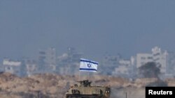 An Israeli military vehicle drives along the border with Gaza amid the ongoing conflict between Israel and the Palestinian Islamist group Hamas, as seen from southern Israel on December 20, 2023. (Clodagh Kilcoyne/Reuters)