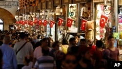 People walk in a covered market in Istanbul, Turkey, Aug. 20, 2018. Tourists have returned in droves to Turkey according to government figures, helped this summer by the sharp fall in the value of the Turkish lira.