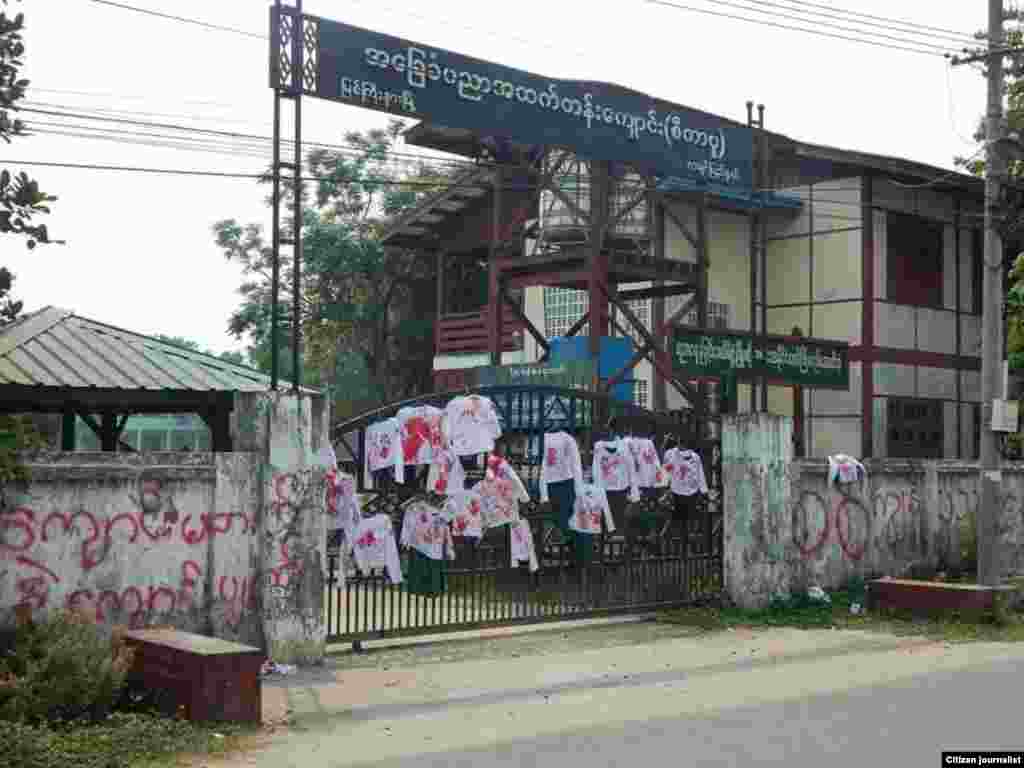 School uniforms with red stains representing bloody crackdowns by Myanmar security forces during anti-coup protests are displayed on the gate of a high school in Myitkyinar, the capital of Kachin State. (Credit: Citizen Journalist)