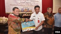 Kepala Badan Geologi Kementerian ESDM, Rudy Suhendar menyerahkan atlas zona kerentanan likuefaksi Indonesia kepada Hidayat Lamakarate selaku Sekretaris Daerah Provinsi Sulawasi Tengah, 9 Oktober 2019. (Foto : Ismail/Humas Pemprov Sulteng)