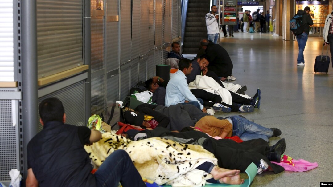 Para migran tidur di lorong kereta api utama di Munich, Jerman (13/9). (Reuters/Michaela Rehle)